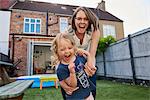 Mother and toddler daughter playing in garden, portrait