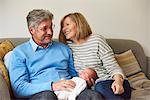 Grandparents on sofa with baby granddaughter