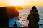 Woman watching sunset, Liscannor, Clare, Ireland