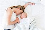Mother and baby asleep in bed