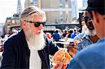 Friends having pizza at food market, London, UK