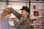 Two female friends, shopping, trying on necklace