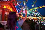 Tourist taking photograph of light decorations, Kek Lok Si Temple, Penang Island, Malaysia