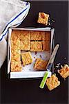 Caramel drizzled blondie squares in a pan with a few cut out