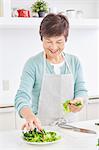 Japanese senior woman with salad in the kitchen