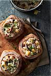 Clam chowder served in bread bowls on a grey wooden table