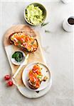 Avocado toast with smoked salmon, dill and radish on a cutting board