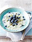 Still life with bowl of fresh blueberries and apple oats