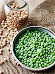 Still life with bowl of peas and jar of chickpeas