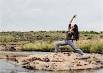 Young female tourist practicing warrior yoga pose at Bourkes Potholes, Mpumalanga, South Africa