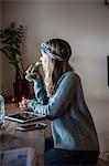 Young woman drinking vegetable juice at cafe window seat