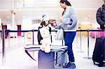 Girl and mother looking at passport in airport departure lounge