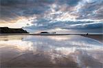 Sunset clouds reflected in wet sand, Rhossili Bay, Gower Peninsula, South Wales, United Kingdom, Europe