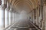 Misty view of pillars with lone woman sitting, Doge's Palace, St. Mark's Square, Venice, UNESCO World Heritage Site, Veneto, Italy, Europe