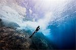 Underwater view of female diver exploring roca partida pinnacle, Socorro, Baja California, Mexico