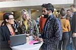 Business people talking, using laptop at conference