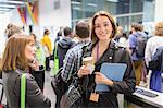 Portrait smiling businesswoman with coffee at conference