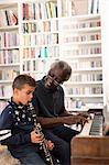 Grandfather and grandson playing piano and clarinet