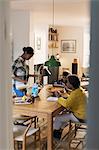 Grandmother and grandchildren baking at dining table