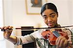 Portrait confident teenage girl playing violin