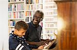 Happy grandfather and grandson playing piano