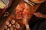 Overhead view woman slicing fresh tomatoes for pizza