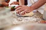 Close up man kneading pizza dough