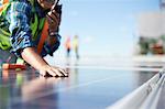 Engineer with walkie-talkie inspecting solar panels at power plant