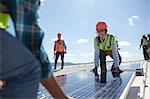 Engineers lifting solar panel at sunny power plant