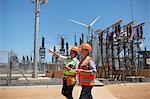 Female engineers with digital tablet at sunny power plant