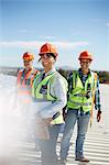 Portrait smiling, confident engineers at sunny power plant