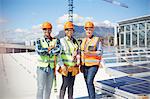 Portrait confident, smiling engineers at sunny solar power plant