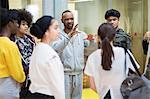 Male instructor leading teenagers in dance class studio