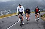 Dedicated male cyclists cycling on uphill road