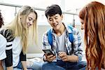 Student showing smart phone to classmates