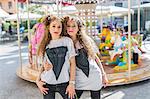 Fashion blogger twins in front of carousel, Mantova, Lombardia, Italy