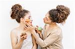 Fashion blogger twins applying face masks, white background