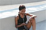 Young woman listening to music on mobile phone