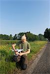 Boy preparing drone in countryside