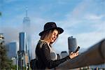 Portrait of woman looking at mobile phone smiling, New York, USA