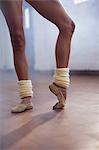 Ballet dancer stretching toes in dance studio