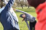 Woman exercising, stretching in park