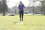 Woman doing speed ladder drill in sunny park