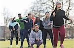 Team cheering woman running in sunny park