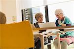 Senior businesswomen using laptops in conference room meeting