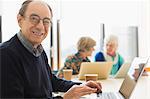 Portrait smiling, confident senior businessman using laptop in conference room meeting