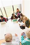 Senior business people using digital tablets and laptops in conference room meeting