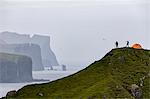 Hikers and tent on cliffs, Kalsoy Island, Faroe Islands, Denmark, Europe