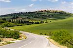 Tuscan road winding through green fields towards Pienza, Tuscany, Italy, Europe