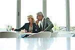 Businesspeople using laptop in cafeteria